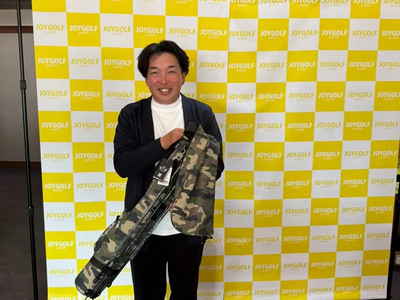 ワールドゴルフ協賛のクラブケースを手にする参加者