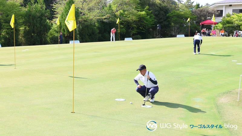 パッティングツアーのグリーンでラインを読むワールドゴルフスタッフ