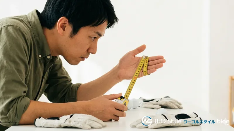 30代日本人男性がメジャーで手囲いを測りグローブのサイズを確認している