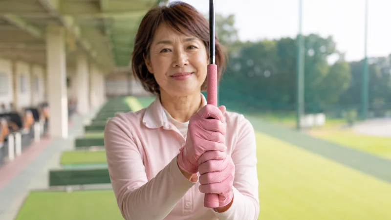 両手グローブでクラブを握る女性ゴルファー