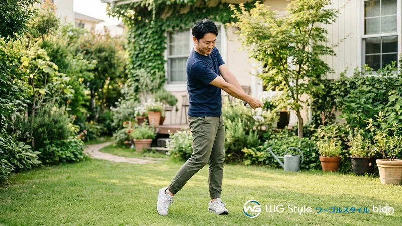 自宅の庭でクラブなしで素振りの動きを練習する30代男性