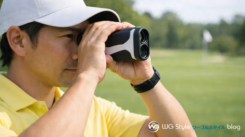 レーザー距離計を目に当てて覗き込むゴルファー。ピンまでの距離を1ヤード以内の精度で計測している場面