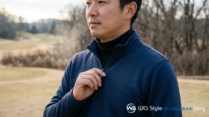 ハーフジップの首元を開けて体温を調節する日本人男性ゴルファーの胸元のクローズアップ