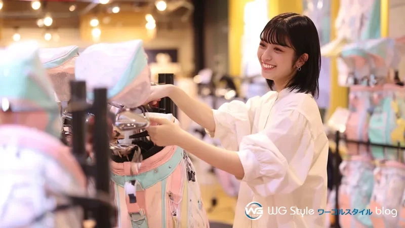 ゴルフショップでパステルカラーのレディース用クラブセットを嬉しそうに眺める30代女性